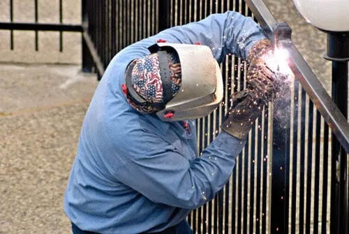 Welder repairing a wrought iron gate in Ohio